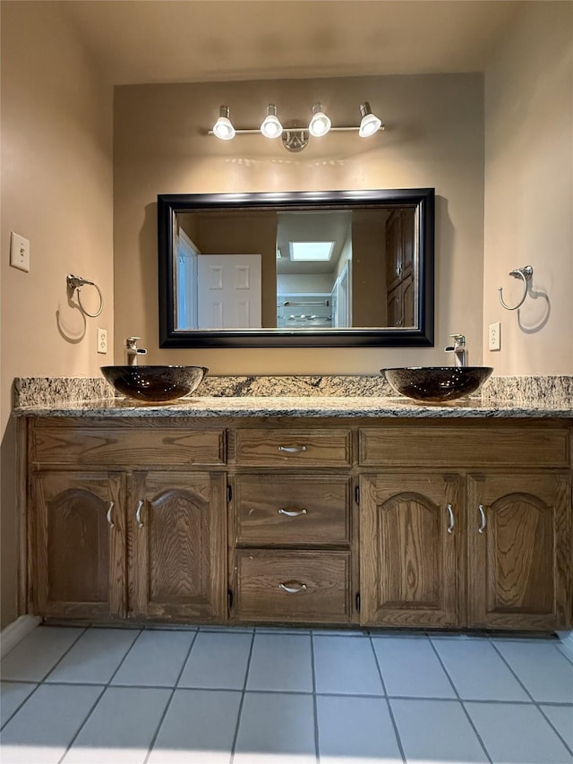 bathroom with double vanity, a sink, and tile patterned floors