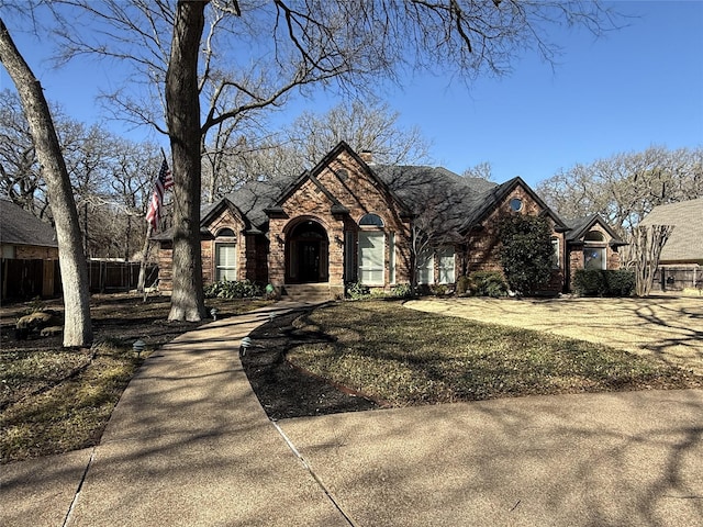 view of front of house with stone siding, fence, and a front yard