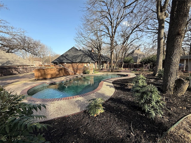 view of swimming pool featuring an outdoor structure, a fenced backyard, and a fenced in pool