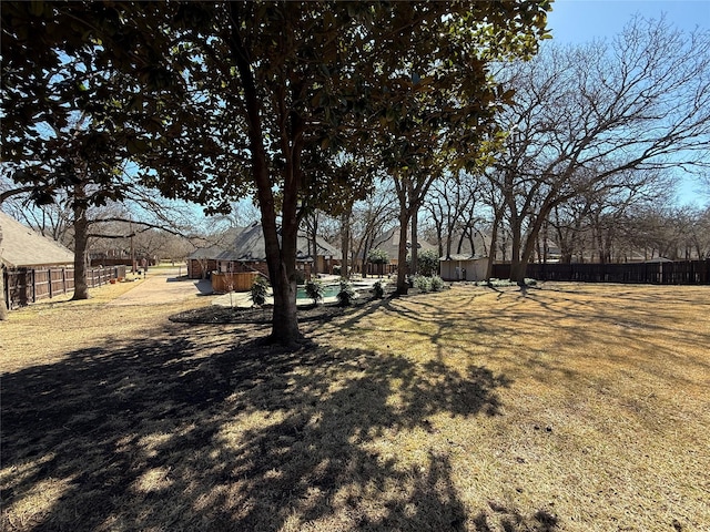 view of yard featuring a storage shed, fence, and an outbuilding