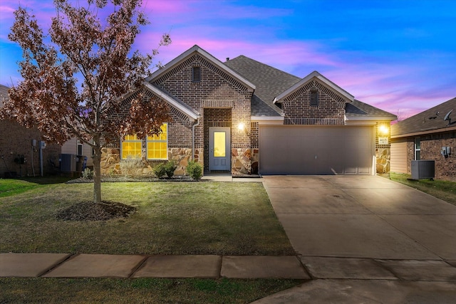 view of front facade with a garage, a shingled roof, brick siding, driveway, and a front lawn