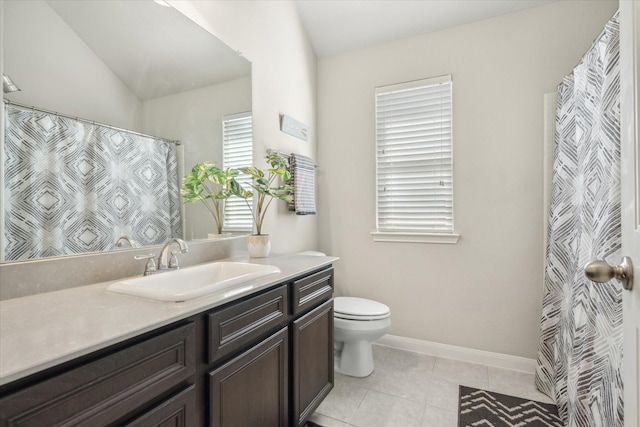 bathroom with baseboards, toilet, tile patterned floors, vaulted ceiling, and vanity