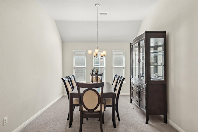 carpeted dining room featuring lofted ceiling, baseboards, and a notable chandelier