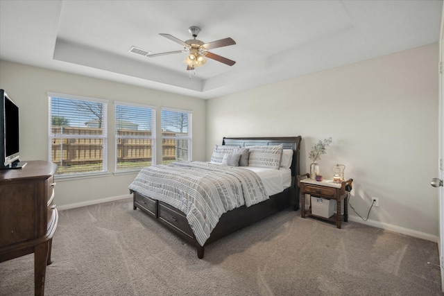 bedroom with carpet, a raised ceiling, visible vents, and baseboards