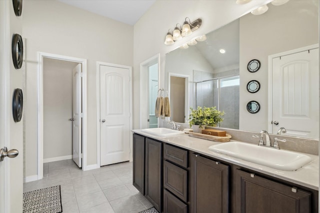 bathroom featuring a stall shower, tile patterned flooring, a sink, and double vanity