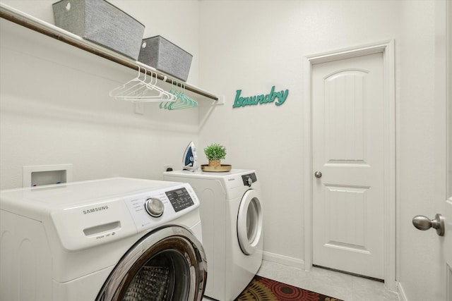 washroom with laundry area, baseboards, separate washer and dryer, and light tile patterned flooring