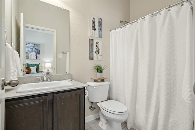 bathroom with toilet, vanity, baseboards, tile patterned floors, and ensuite bath