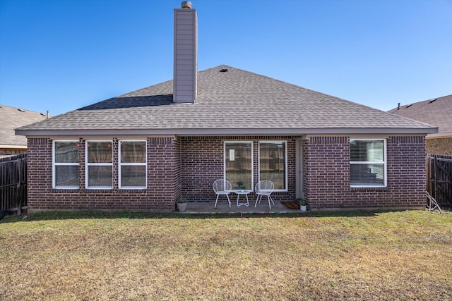 rear view of property featuring a patio, a yard, a chimney, and fence