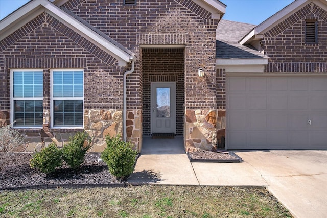 view of front of house featuring an attached garage, stone siding, a shingled roof, and brick siding