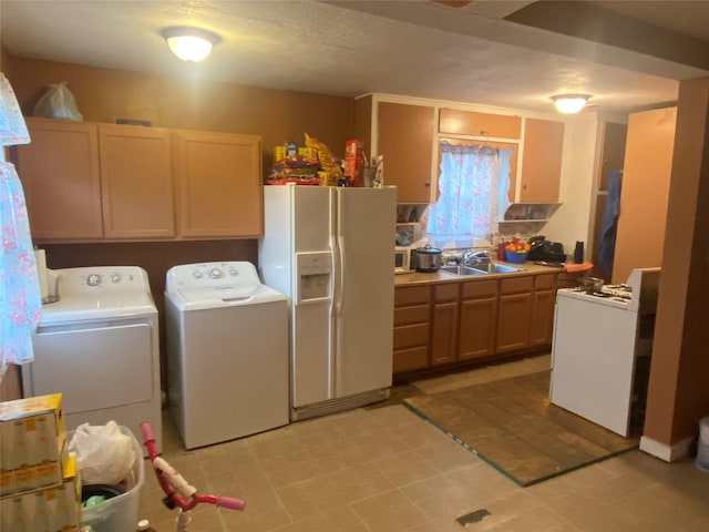 clothes washing area with a sink and washing machine and clothes dryer