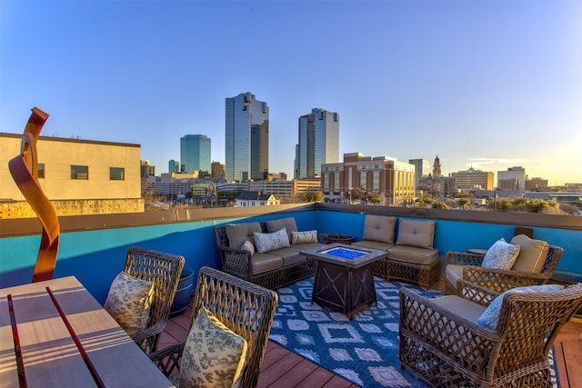 view of patio featuring a view of city, outdoor dining area, and an outdoor living space with a fire pit