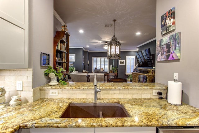 kitchen featuring light stone countertops, visible vents, ornamental molding, decorative backsplash, and dishwasher