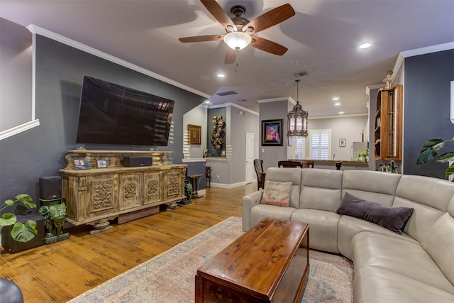 living area with recessed lighting, wood finished floors, visible vents, a ceiling fan, and ornamental molding