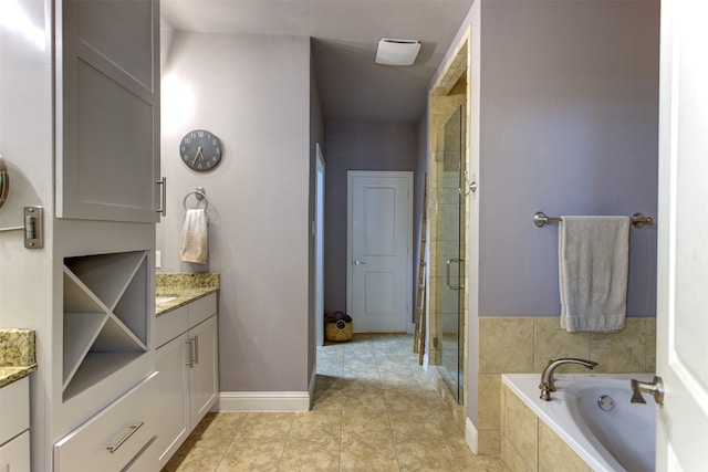 bathroom with a stall shower, baseboards, tile patterned floors, a garden tub, and vanity