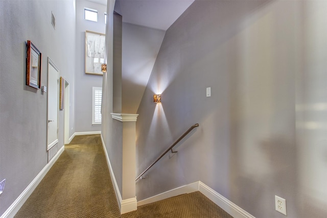 hallway featuring baseboards, visible vents, carpet flooring, and an upstairs landing