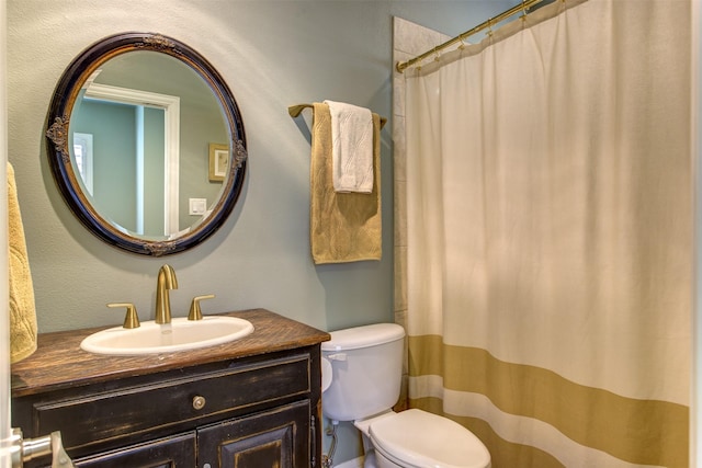 bathroom featuring toilet, curtained shower, and vanity