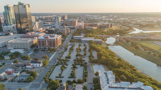 aerial view at dusk featuring a water view and a city view