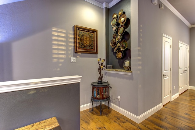 hallway featuring baseboards, crown molding, and hardwood / wood-style floors