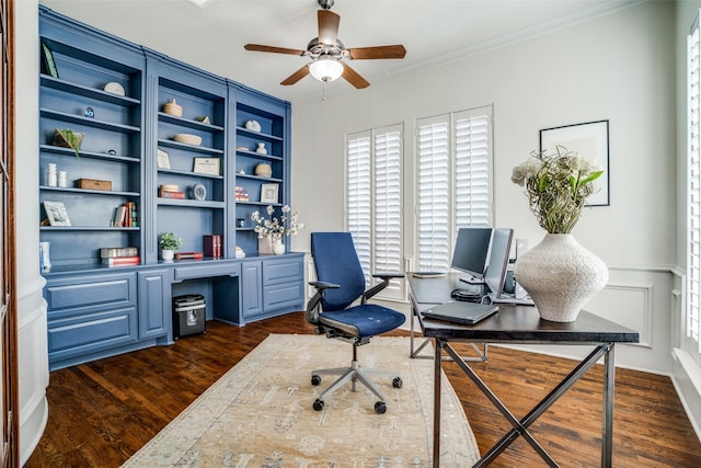 office area with ceiling fan, dark wood-style flooring, built in features, built in desk, and crown molding