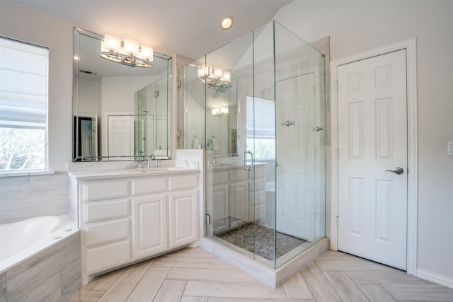 bathroom featuring a bath, a shower stall, vanity, and an inviting chandelier