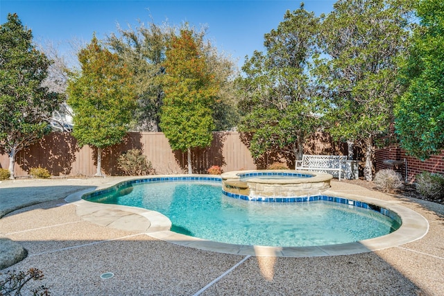 view of swimming pool featuring a patio, a fenced backyard, and a pool with connected hot tub