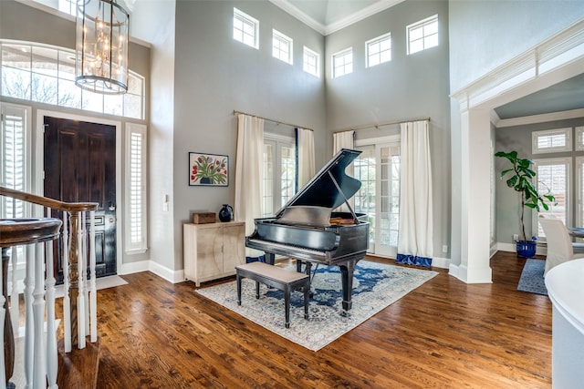 entrance foyer featuring ornamental molding, plenty of natural light, wood finished floors, and baseboards