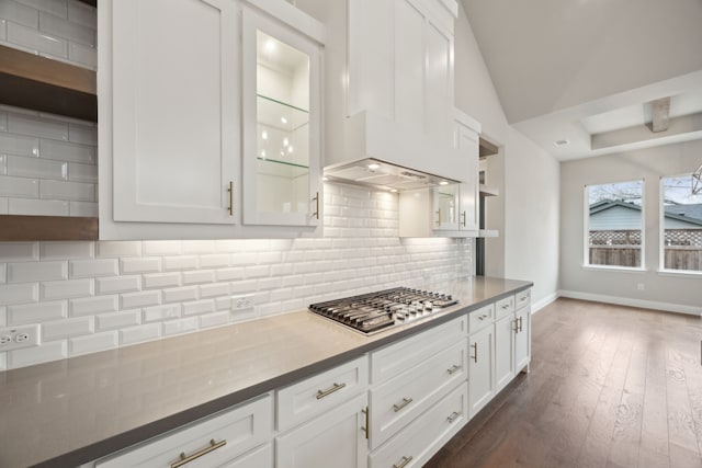 kitchen featuring stainless steel gas cooktop, white cabinetry, custom exhaust hood, decorative backsplash, and open shelves