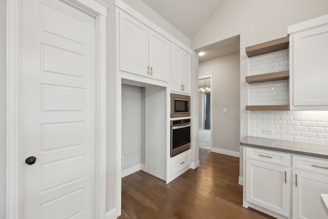 kitchen with appliances with stainless steel finishes, vaulted ceiling, backsplash, and open shelves