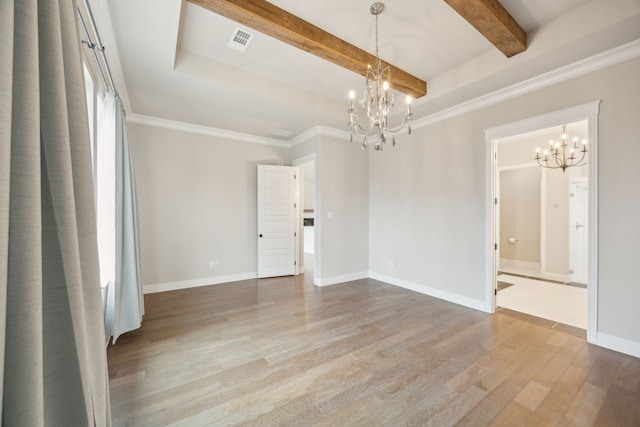 spare room featuring a chandelier, visible vents, baseboards, and wood finished floors