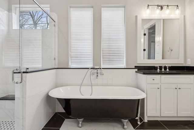 full bath with a freestanding tub, a shower stall, and tile walls