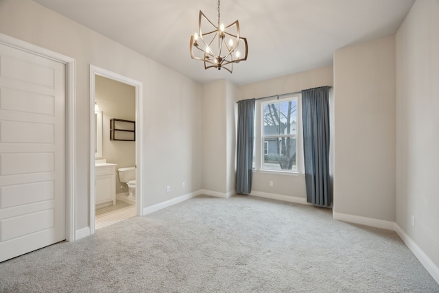 unfurnished room with carpet, baseboards, and a notable chandelier