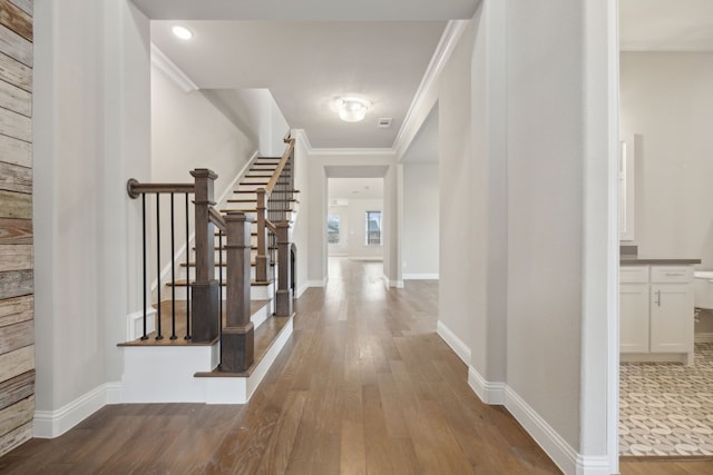 foyer with ornamental molding, stairway, baseboards, and wood finished floors