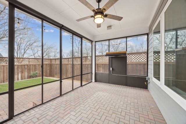 unfurnished sunroom with ceiling fan