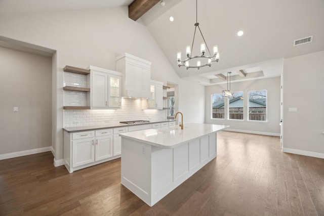 kitchen with dark wood-style floors, open shelves, visible vents, and stainless steel gas stovetop