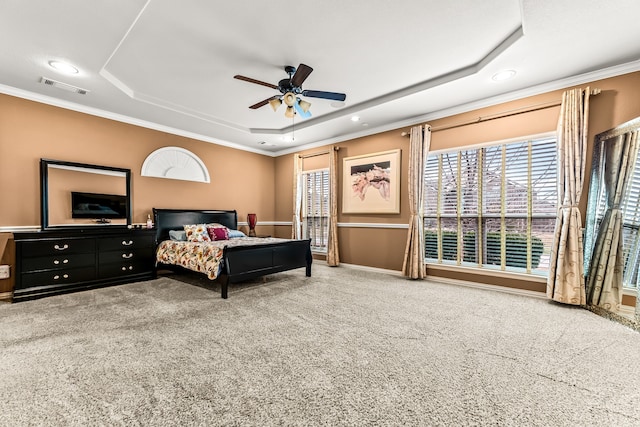 carpeted bedroom with ornamental molding, a raised ceiling, visible vents, and baseboards