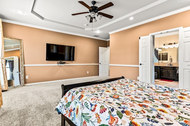 carpeted bedroom with ornamental molding, a tray ceiling, visible vents, and baseboards