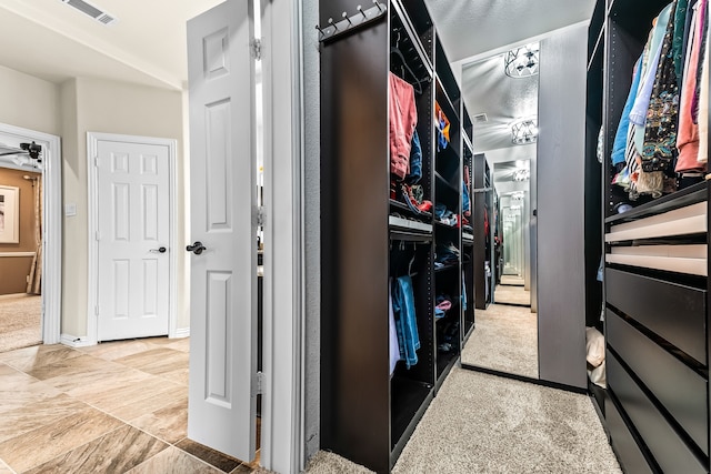 walk in closet with visible vents and a ceiling fan