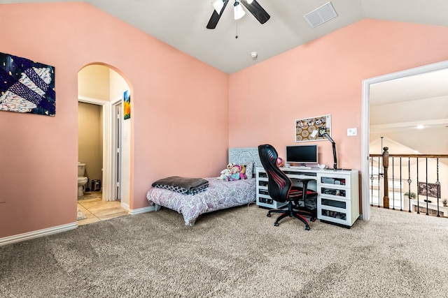 carpeted bedroom featuring visible vents, arched walkways, ceiling fan, ensuite bath, and vaulted ceiling