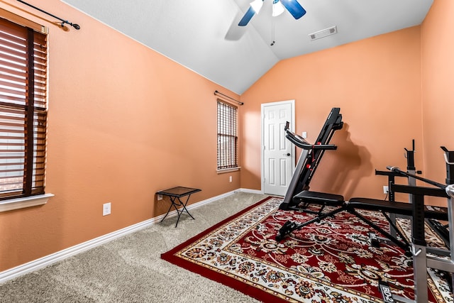 exercise area featuring lofted ceiling, carpet flooring, a ceiling fan, visible vents, and baseboards