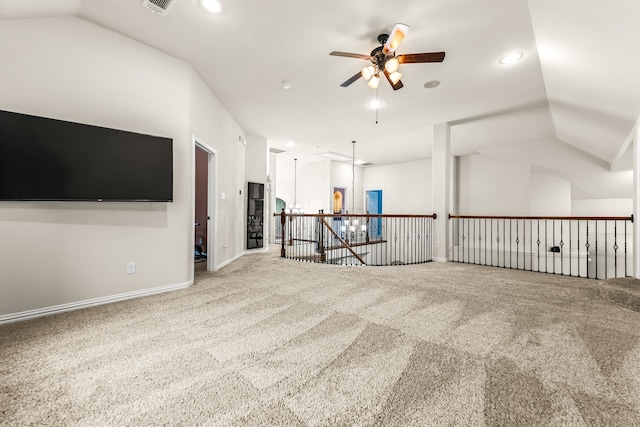 empty room with carpet flooring, vaulted ceiling, baseboards, and ceiling fan