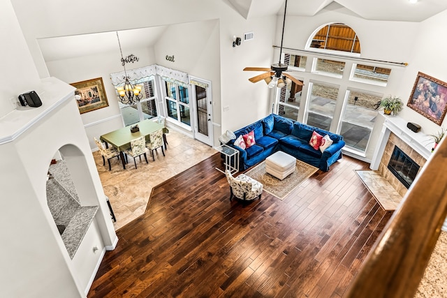 living area with high vaulted ceiling, hardwood / wood-style floors, and a fireplace