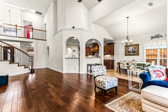 living area with a chandelier, hardwood / wood-style floors, stairs, and visible vents