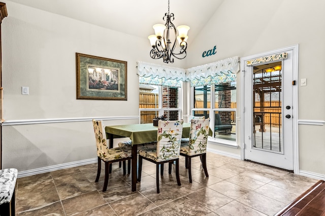 dining area with lofted ceiling, baseboards, and a notable chandelier