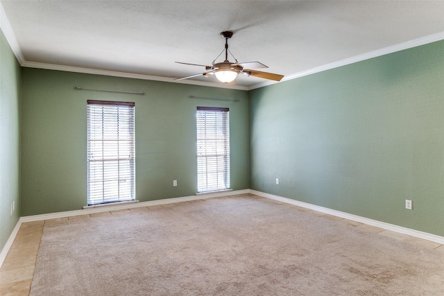 spare room featuring ornamental molding, light carpet, ceiling fan, and baseboards