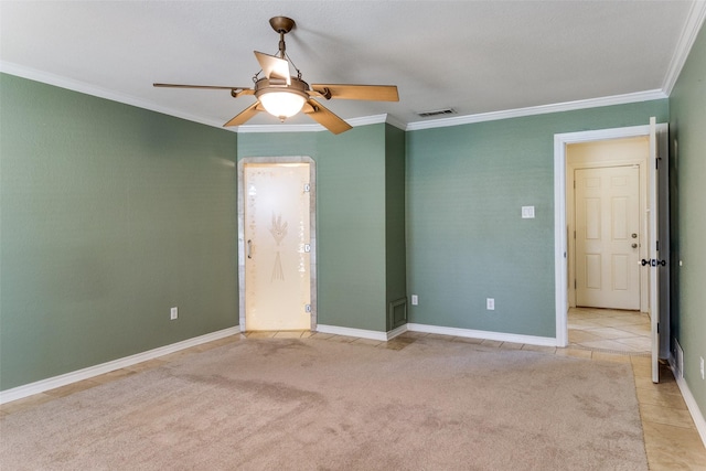 empty room with light carpet, visible vents, ceiling fan, crown molding, and light tile patterned flooring