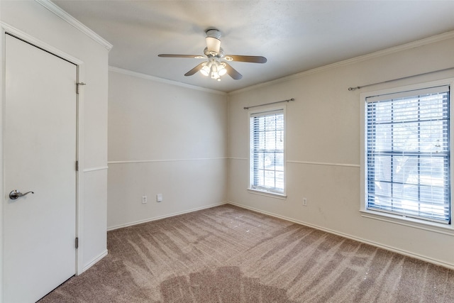 unfurnished room with carpet, a ceiling fan, and crown molding