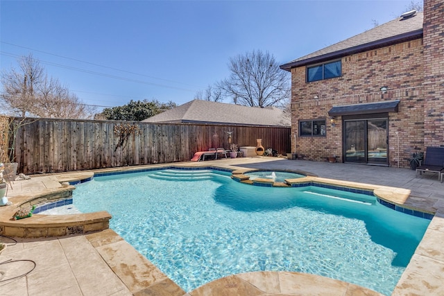 view of swimming pool featuring a patio area, a fenced backyard, and a pool with connected hot tub