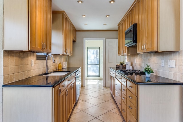 kitchen featuring dark countertops, decorative backsplash, light tile patterned flooring, a sink, and black appliances