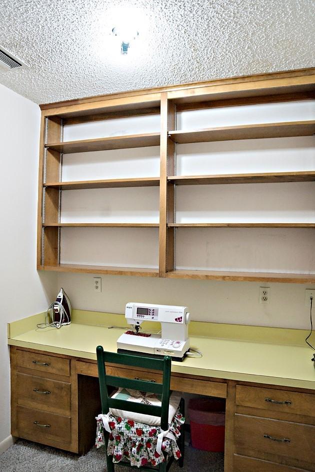 carpeted home office with baseboards, visible vents, and built in desk