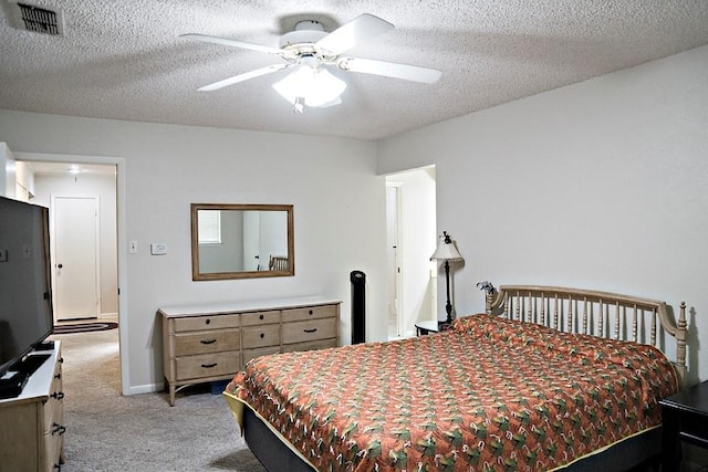 bedroom featuring visible vents, light carpet, ceiling fan, a textured ceiling, and baseboards